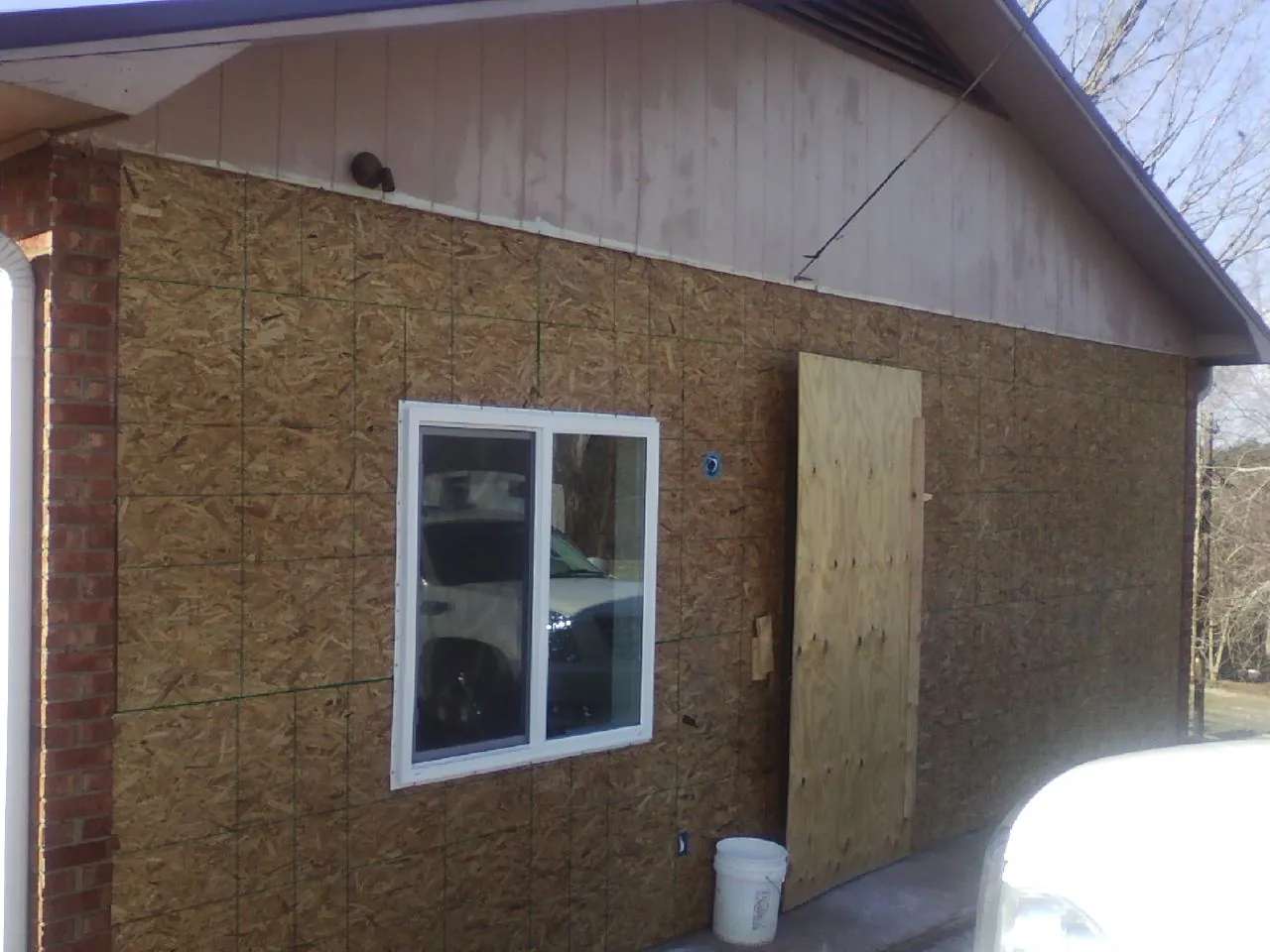 OSB sheathing on a garage addition wall before siding in Mason